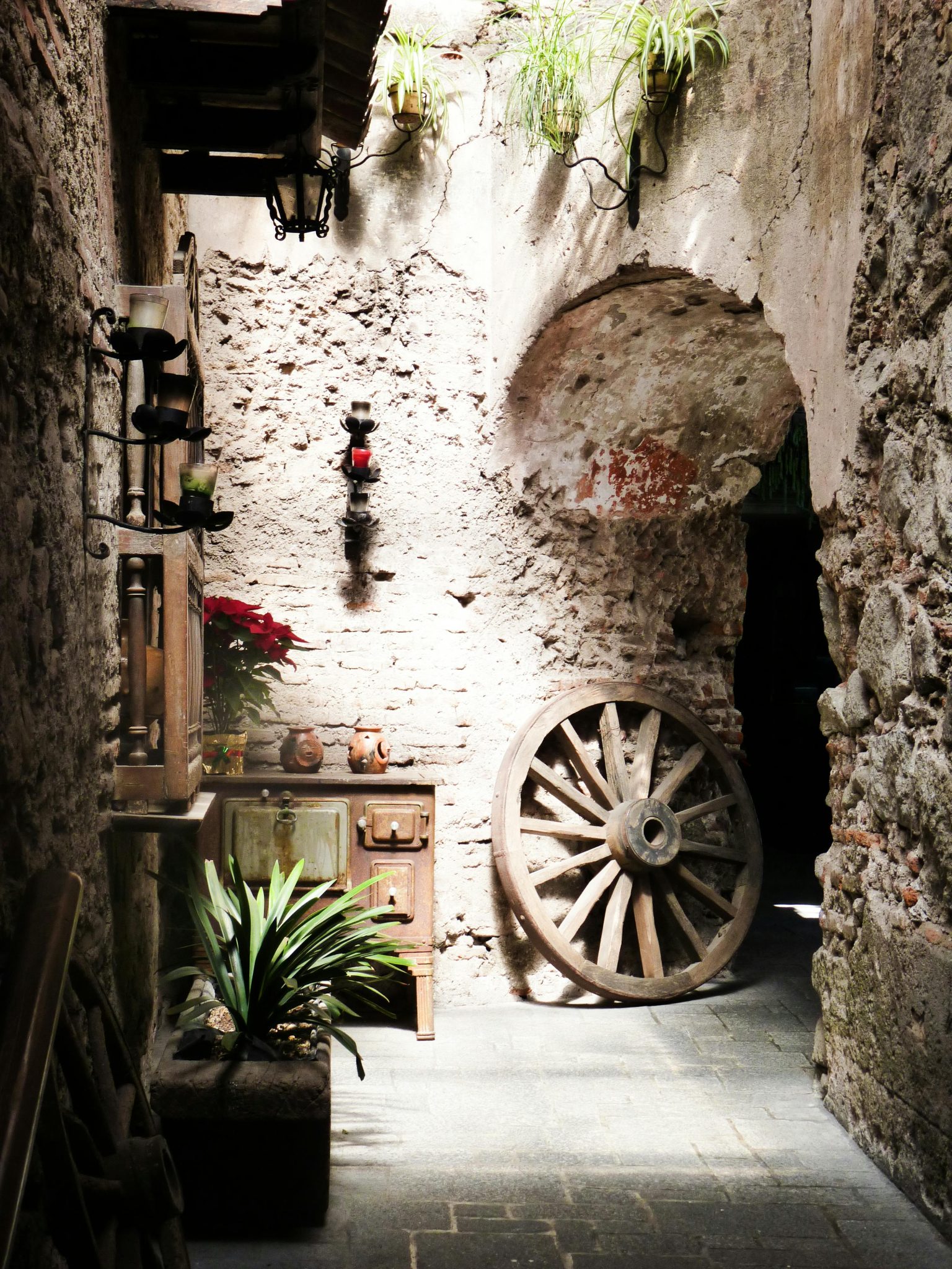 Explore a rustic corner patio in Antigua Guatemala featuring stone walls and antique decor.