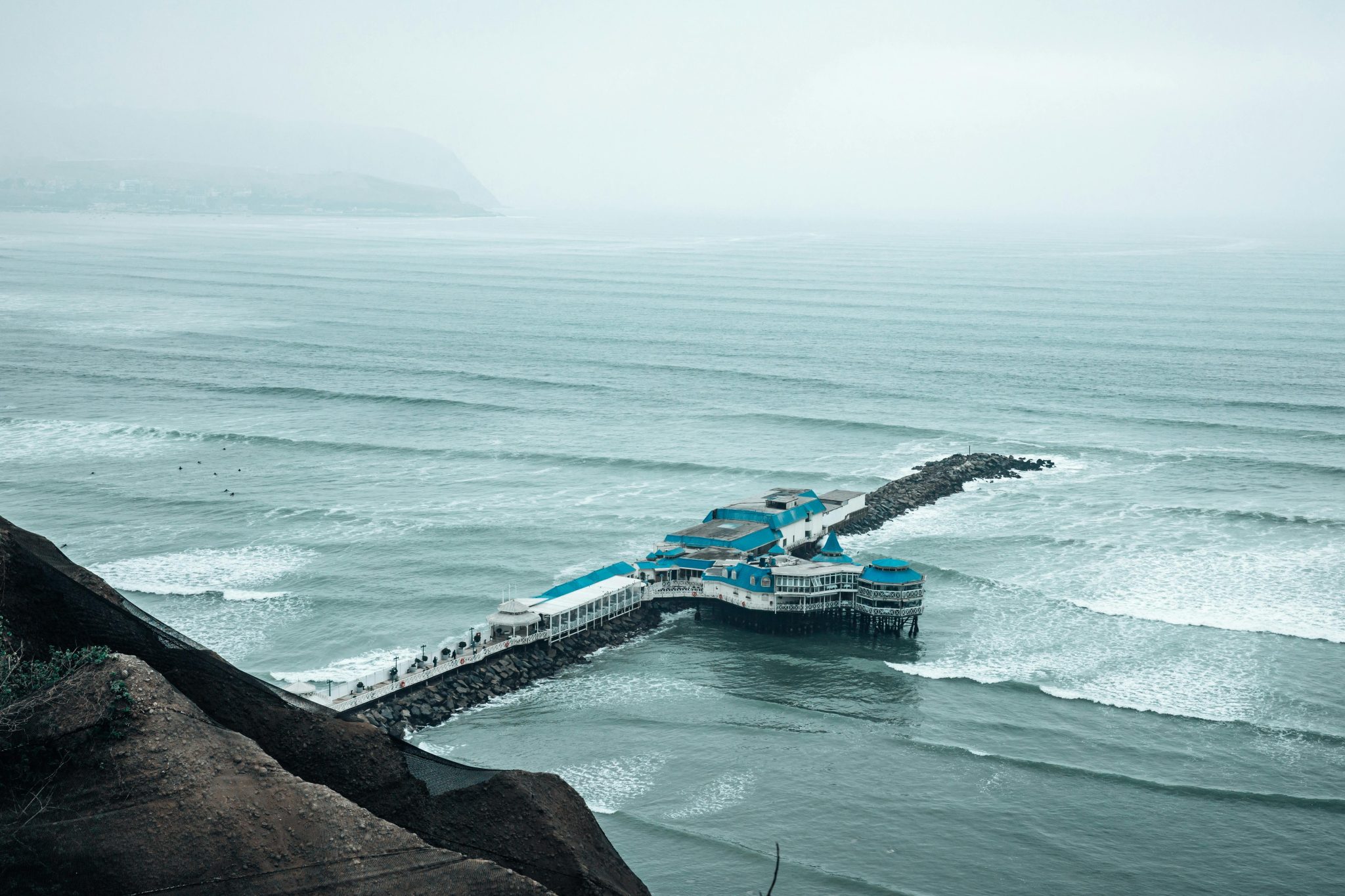 Aerial view of La Rosa Nautica pier in Lima, Peru under foggy skies.