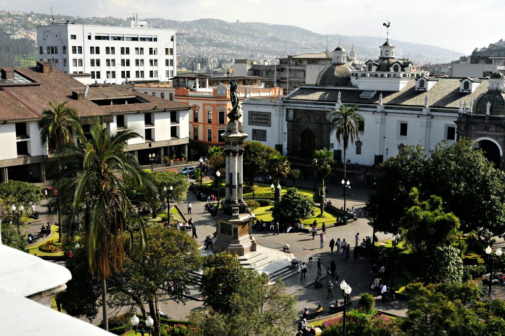 A vibrant aerial view of Plaza Grande in Quito, showcasing historical architecture and lush greenery.