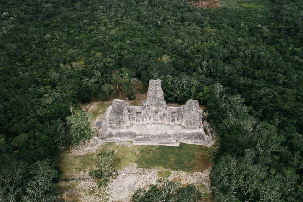 An aerial view showcasing ancient Mayan ruins surrounded by lush jungle.